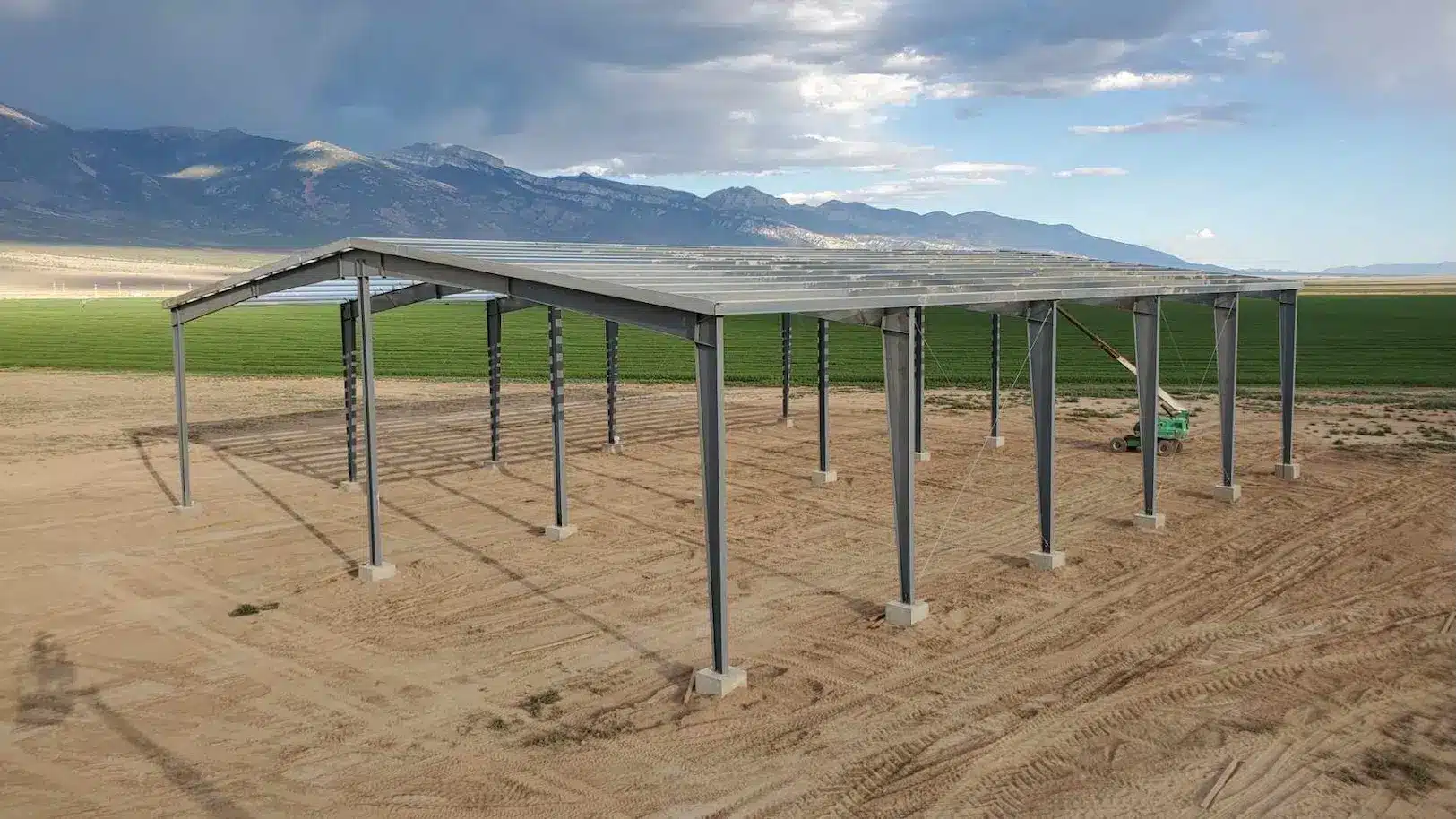 Pre-engineered metal building under construction against mountain landscape